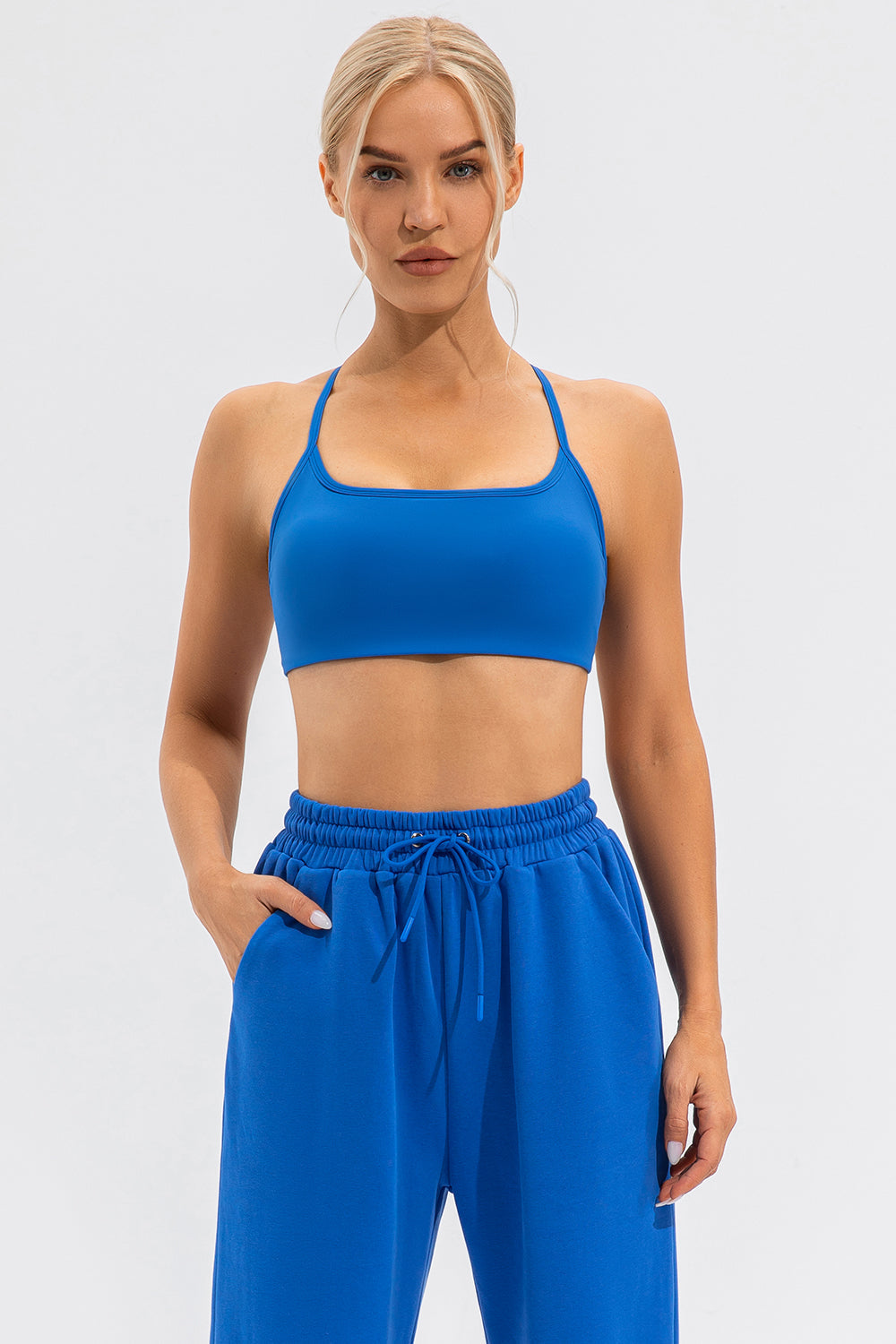 Blue sports bra with crisscross back straps and a square neckline.