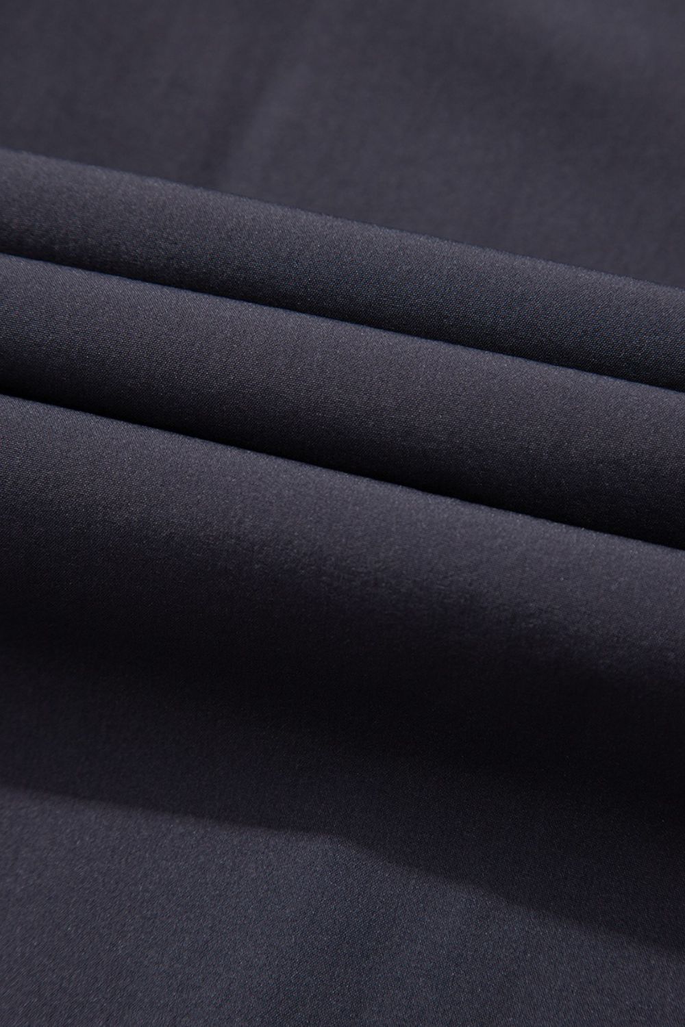 Dark gray gathered-leg jumpsuit fabric detail