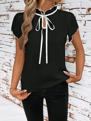 Black maternity blouse with frilled tie-neck and white trim detail.
