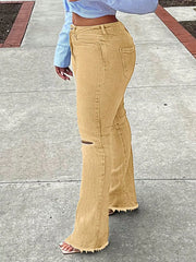 Yellow distressed flare jeans with raw hem and knee rip detail.