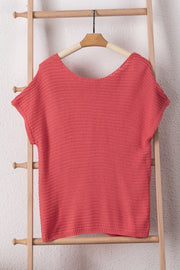 Open-knit dolman sleeve top in watermelon pink acrylic with a boat neckline.