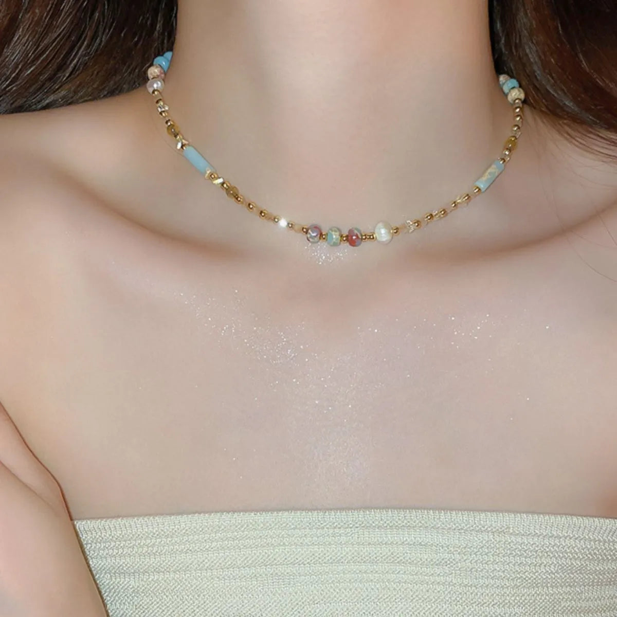 Multi-strand beaded collar necklace with multicolor gemstones and light blue accents.
