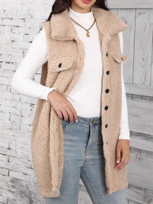 Tan sherpa utility vest with collar and button front, styled with a white turtleneck and jeans.