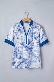 White polyester shirt with blue toile print, V-neck, short sleeves, and contrast trim.