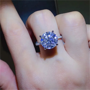 Sterling silver ring with a large round solitaire diamond and small accent stones on the band.