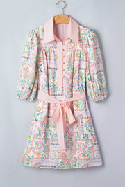 Floral patchwork mini dress with 3/4 sleeves, button-down front, and pink belt.