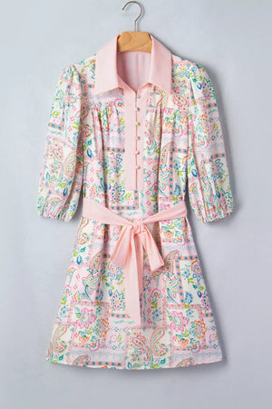 Floral patchwork mini dress with 3/4 sleeves, button-down front, and pink belt.