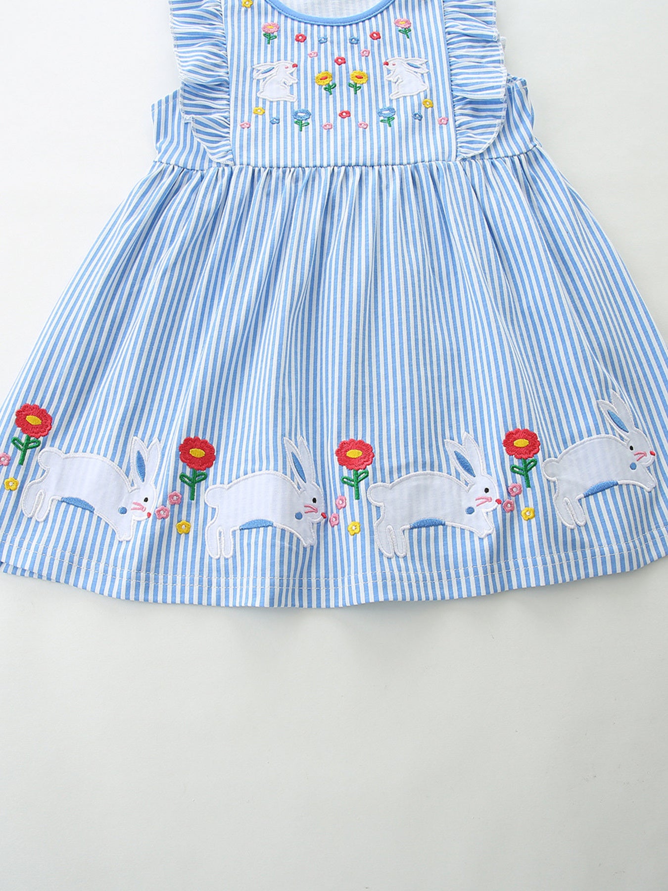 Blue striped cotton toddler dress with embroidered bunnies and flowers on bodice and hem.