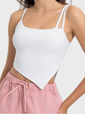 White asymmetric cutout cami top with double spaghetti straps and a handkerchief hem.