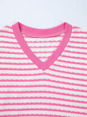 Textured V-neck t-shirt with pink and white horizontal stripes and pink trim.