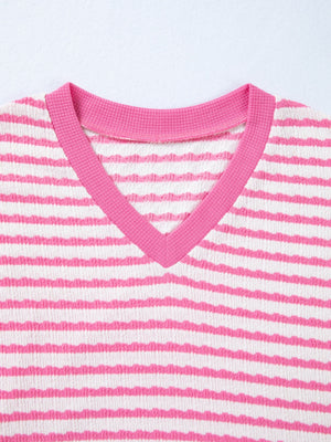 Textured V-neck t-shirt with pink and white horizontal stripes and pink trim.