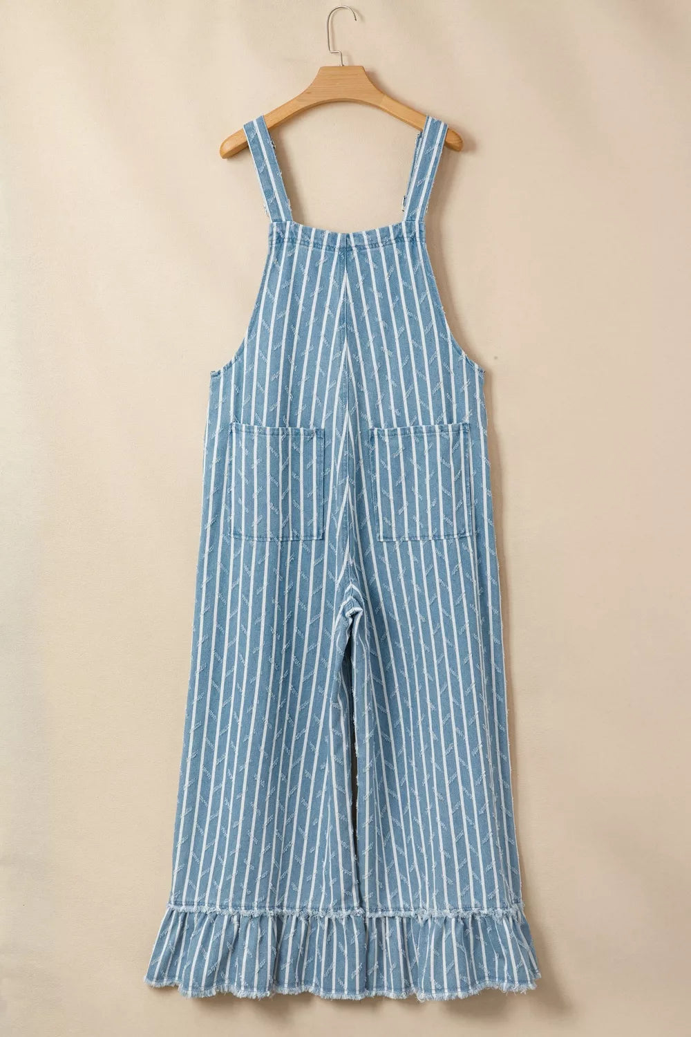 Striped denim overalls with wide legs, distressed details, and ruffled hem.