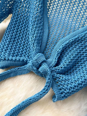 Blue knit tied crop top with open weave detail and tie closure.
