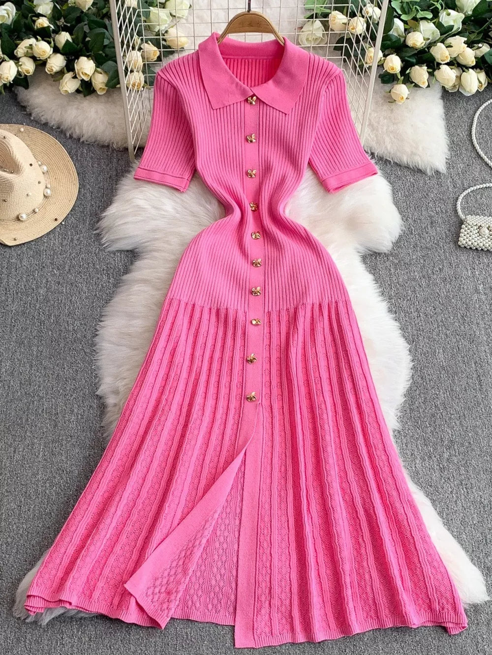 Pink ribbed knit midi dress with collar, short sleeves, and gold button detail.
