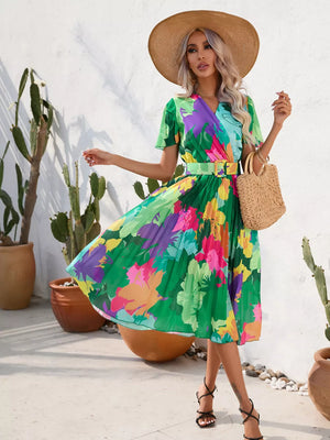 Tropical pleated midi dress with belt in vibrant floral print and green.