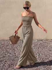 Smocked strapless wide-leg romper in olive green with frill detail.