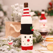 Festive knit wine bottle holder with red and white stripes, black hat, and snowman face details.