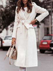Belted longline trench coat in white with flap pockets and tie waist.