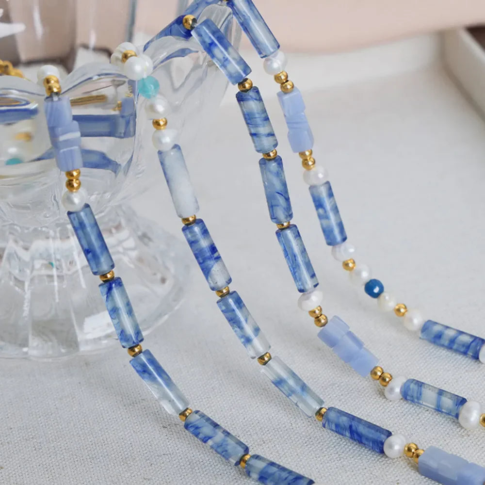 Lapis lazuli and pearl bead necklace with gold accents, light blue.