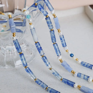 Lapis lazuli and pearl bead necklace with gold accents, light blue.