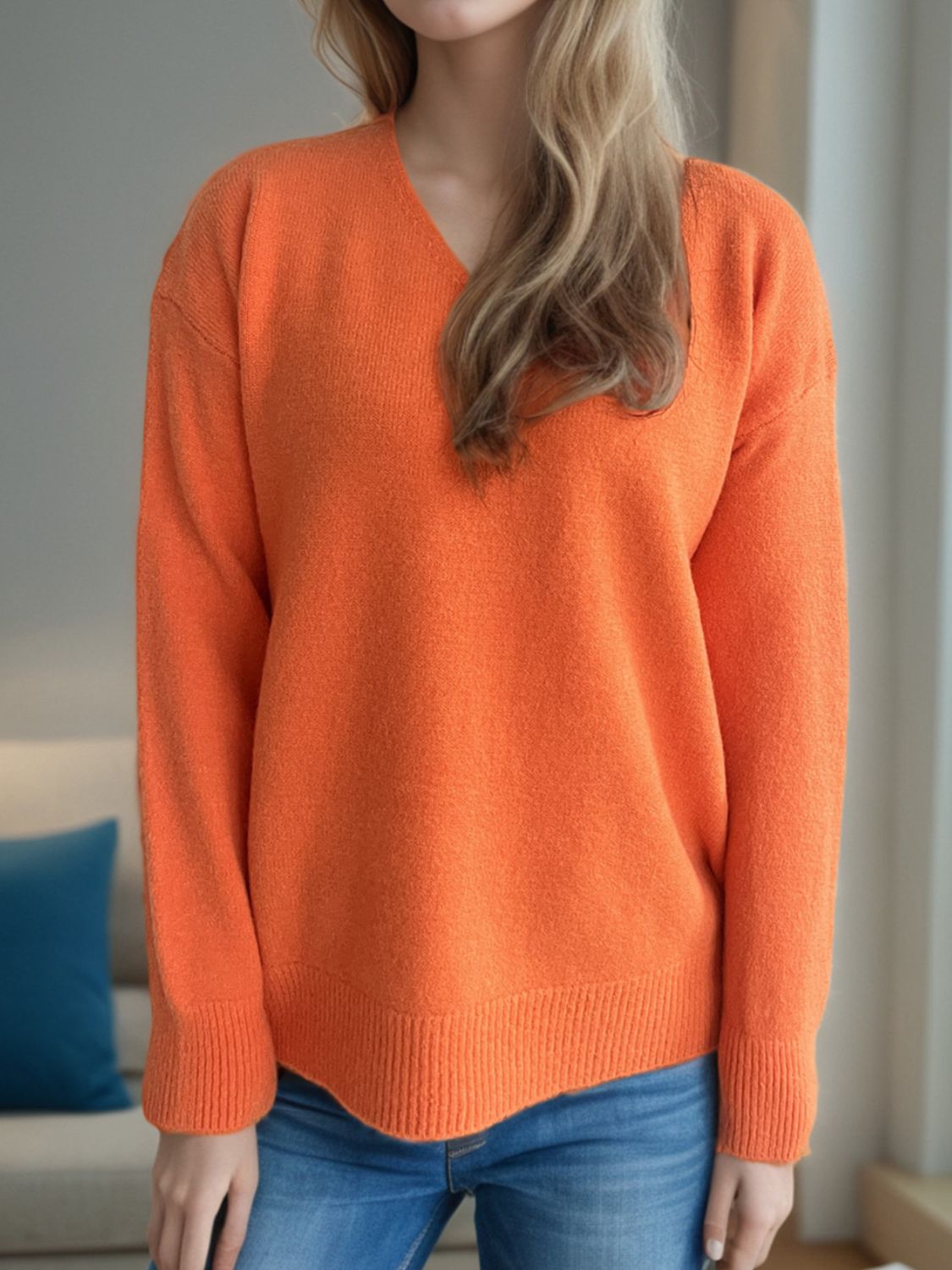 Orange V-neck acrylic knit sweater with ribbed hem and cuffs.