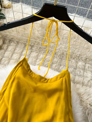 Yellow backless halter dress with tie neck detail.