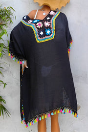 Black kaftan dress with colorful crochet yoke and tassel trim on sleeves and hem