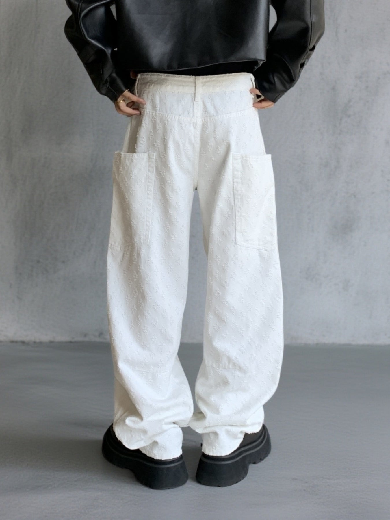 White textured cotton wide-leg jeans with large front pockets and curved seams.