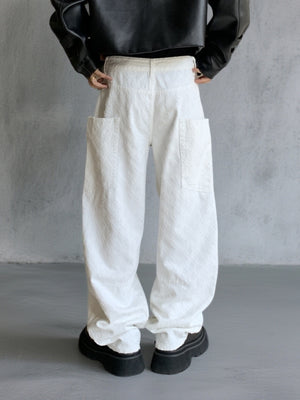 White textured cotton wide-leg jeans with large front pockets and curved seams.