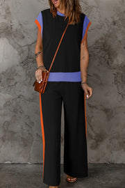 Colorblock sportswear set with black top, blue waistband, and orange trim pants.