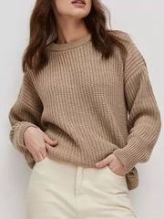 Chunky knit camel sweater with relaxed fit and crew neck, styled casually.