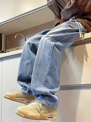 Blue vintage wash straight-leg jeans with drawstring and leather patch detail.
