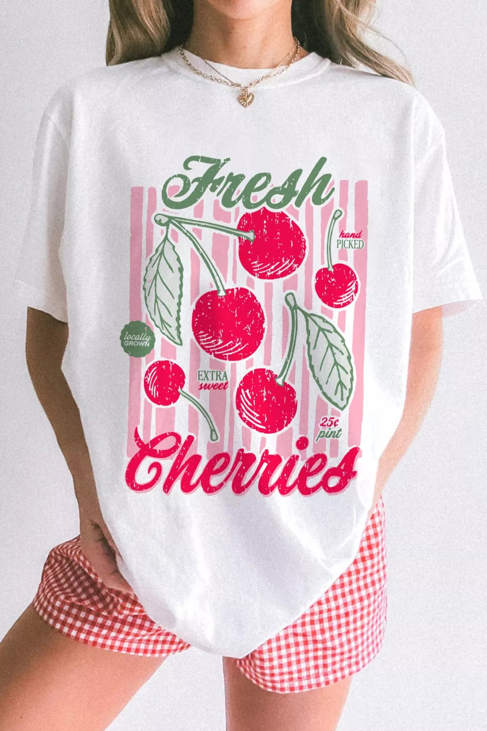 White oversized tee with vintage cherry graphic and pink stripes.