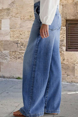 Light wash denim jeans with subtle stitching detail and a wide-leg cut.