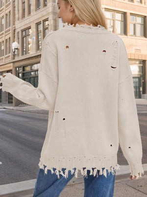 Cream knit sweater with frayed details and distressed holes, crew neck, long sleeves.