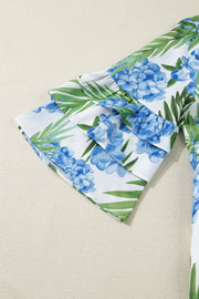 Mini dress with hydrangea and palm print, featuring ruffled short sleeves.