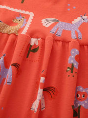 Toddler dress with whimsical horse and flower print on orange cotton blend fabric.