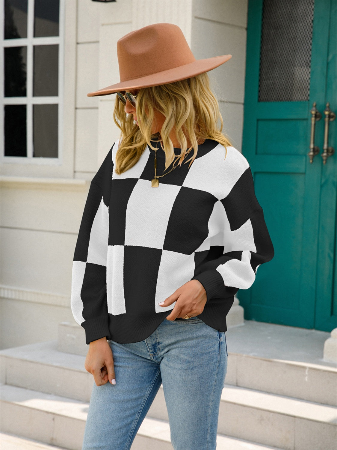 Checkerboard knit pullover sweater in black and white with balloon sleeves.