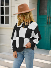 Checkerboard knit pullover sweater in black and white with balloon sleeves.