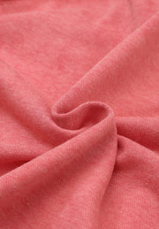 Washed cotton utility jacket in burnt coral, showing fabric texture and drape.
