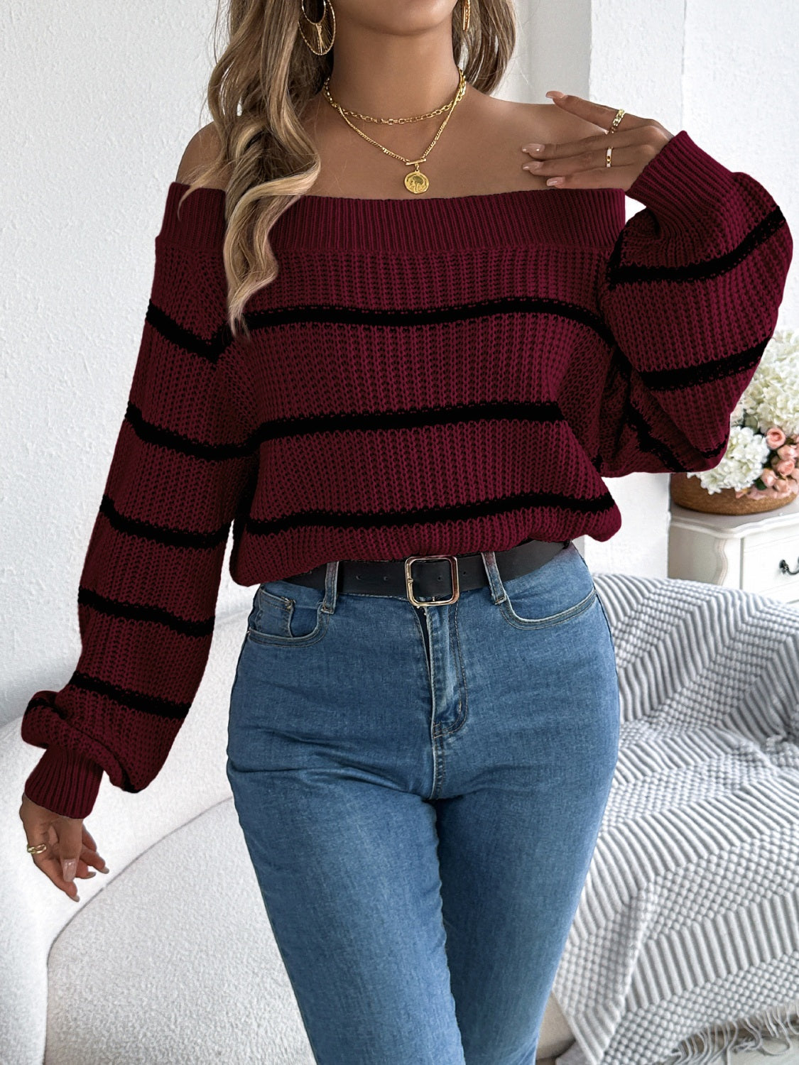 Burgundy off-the-shoulder striped knit pullover sweater with long sleeves.