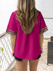 Pink split neck blouse with leopard trim on sleeves.