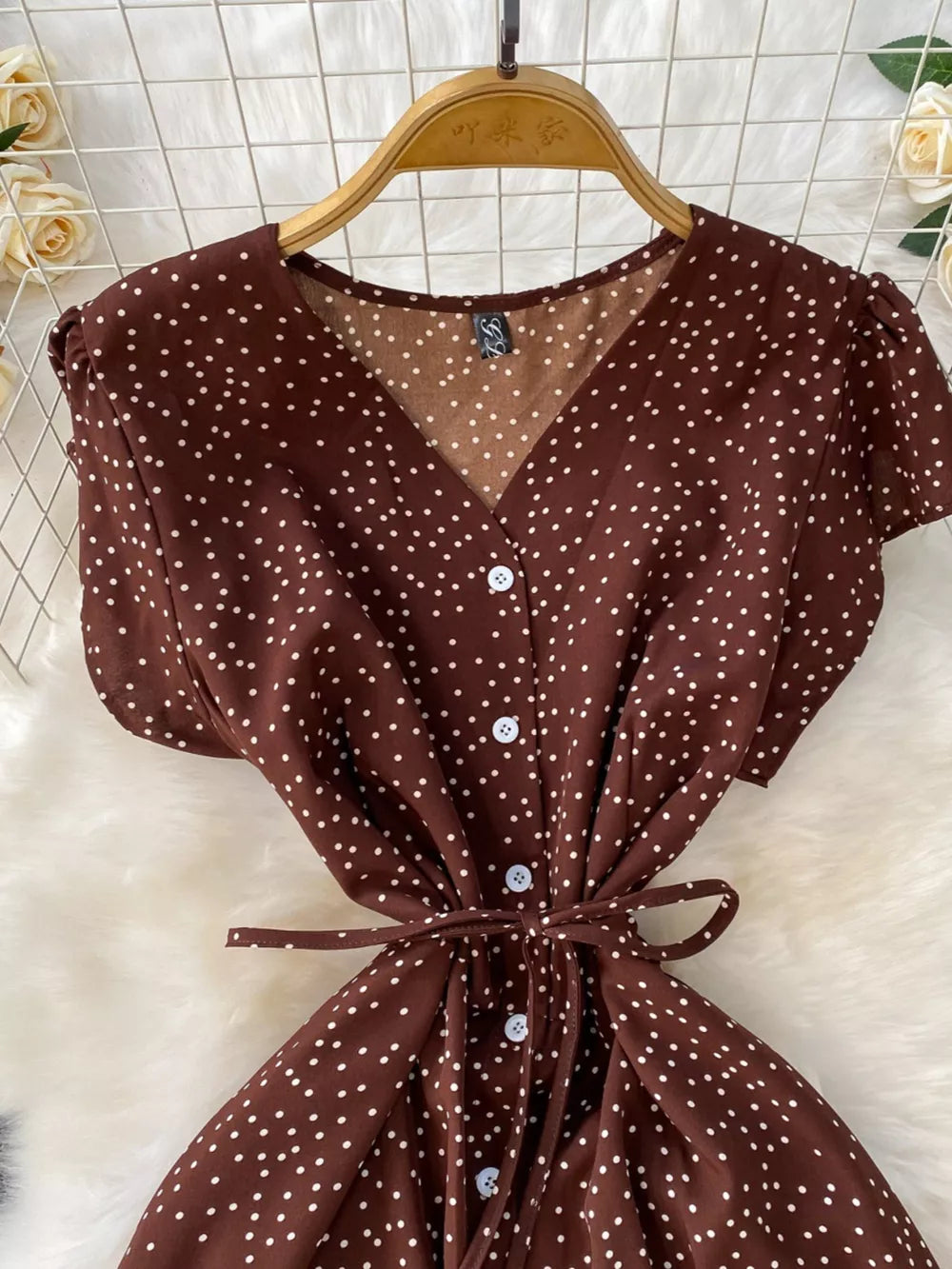 Brown polka dot maxi dress with V-neck, button front, short sleeves, and tie belt.