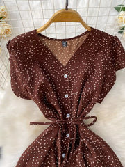 Brown polka dot maxi dress with V-neck, button front, short sleeves, and tie belt.