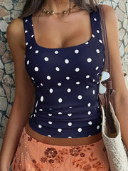 Navy blue polka dot scoop neck tank top with a cropped fit.