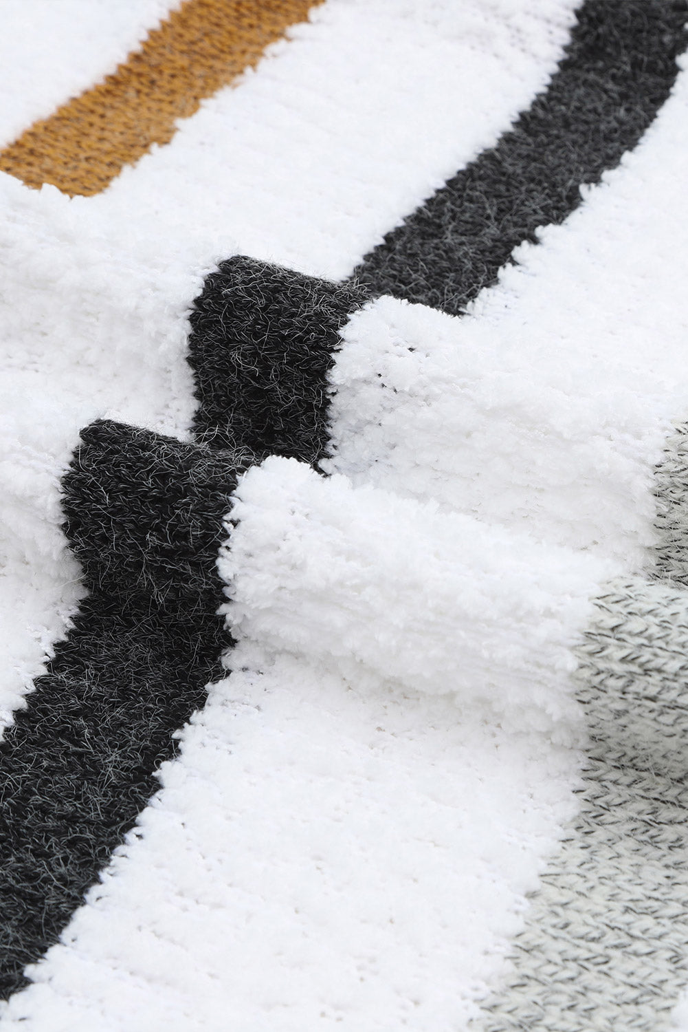 Textured stripe slouchy knit sweater in white with black and gold stripes.