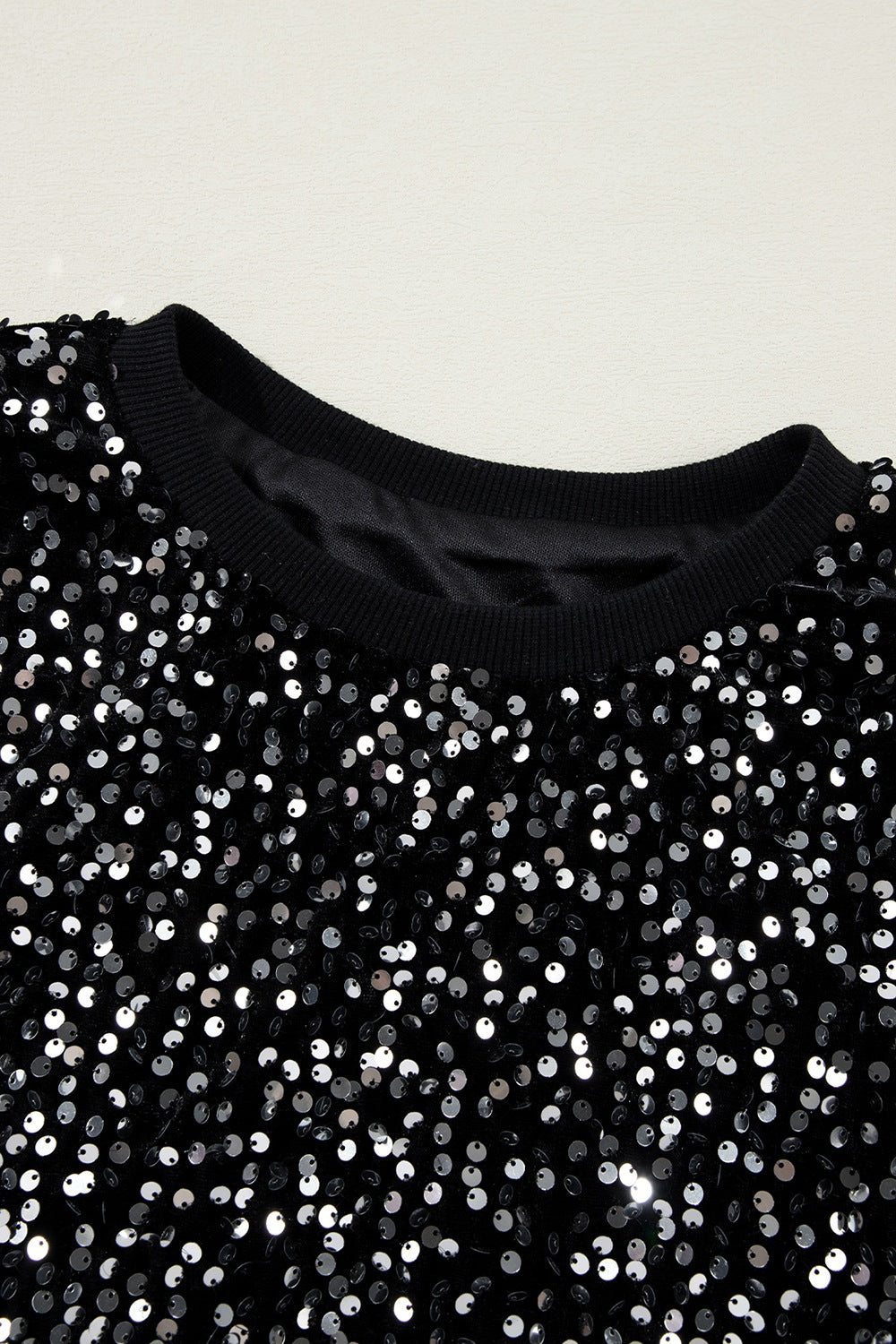 Black sequin embellished sweatshirt with ribbed cuffs and neckline.