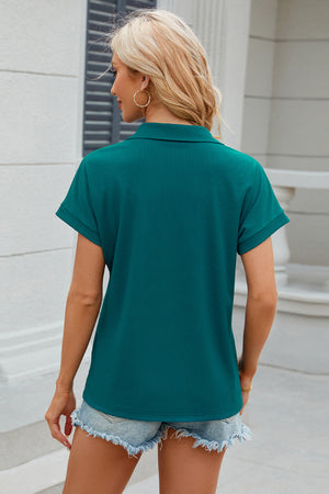 Teal textured polo top with cuffed short sleeves and a collar.
