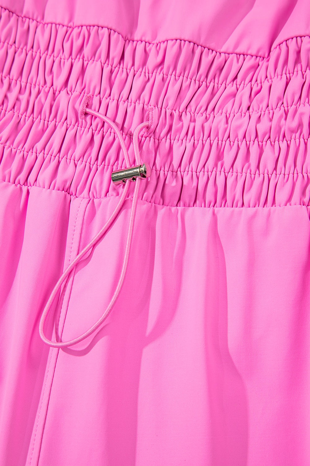 Fuchsia pink active romper set with ruched waistband and drawstring detail.