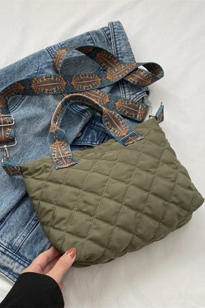 Moss green quilted satchel with patterned strap and denim.